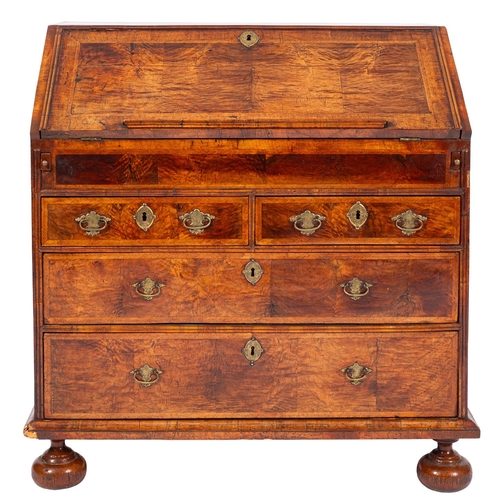 807 - A George II featherbanded walnut bureau, circa 1735; the fall front with a bookrest along the lower ... 