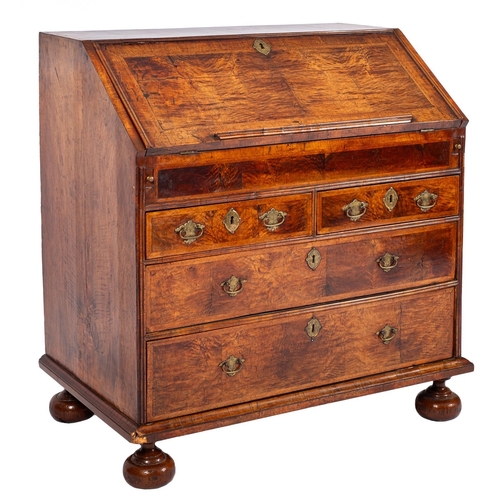 807 - A George II featherbanded walnut bureau, circa 1735; the fall front with a bookrest along the lower ... 