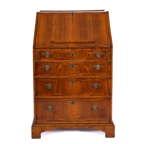 815 - A 19th Century walnut bureau, of small size, with cross and feather banding, the sloping hinged fall... 