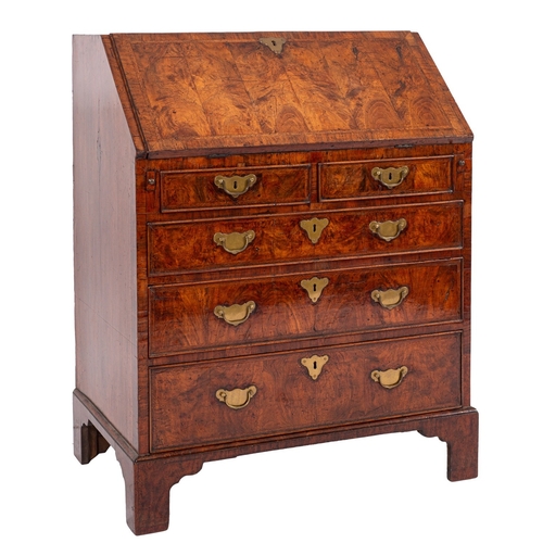 817 - A George II walnut and feather banded bureau, circa 1740; the fall front opening to a fitted interio... 