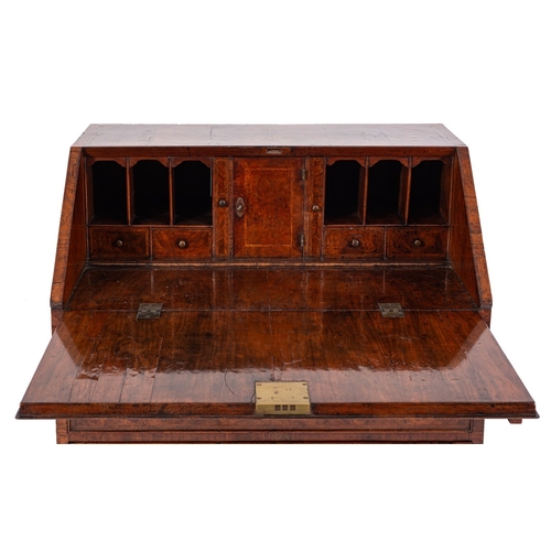 817 - A George II walnut and feather banded bureau, circa 1740; the fall front opening to a fitted interio... 