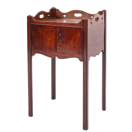 822 - A George III mahogany tray top bedside cupboard, the shaped three quarter gallery with pierced motif... 