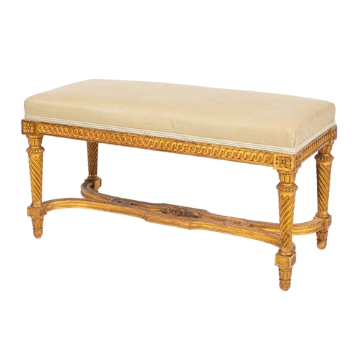 879 - A carved giltwood and upholstered long stool, in Louis XVI style, circa 1900; the rectangular seat w... 