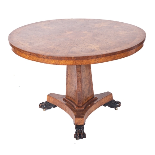 918 - A Regency burr oak centre table, early 19th century; the circular tilt top with a central circular r... 