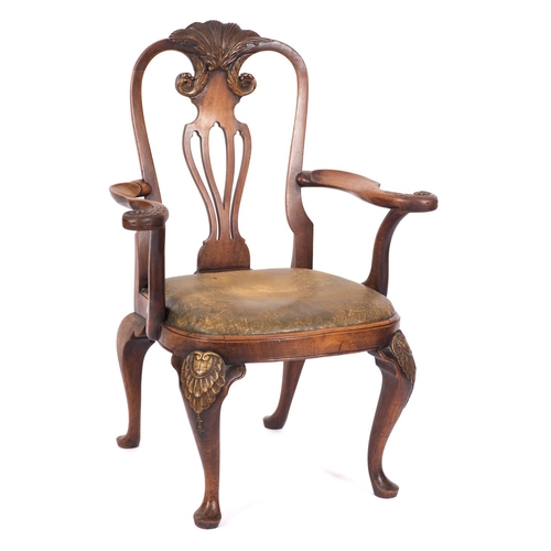 949 - A carved walnut and beechwood and parcel gilt open armchair in George I style; the cartouche shaped ... 