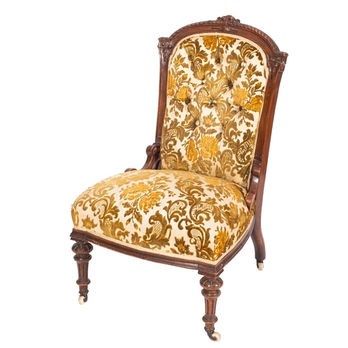 980 - A late Victorian carved walnut and button upholstered salon chair, circa 1900; the arched backrest w... 