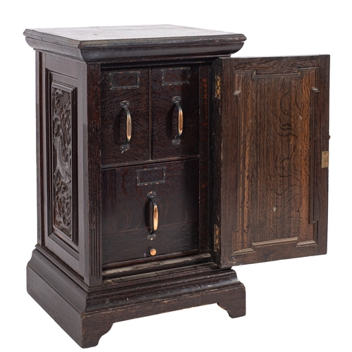 981 - A late Victorian/Edwardian dark oak pedestal cabinet, the interior fitted with three filing drawers,... 