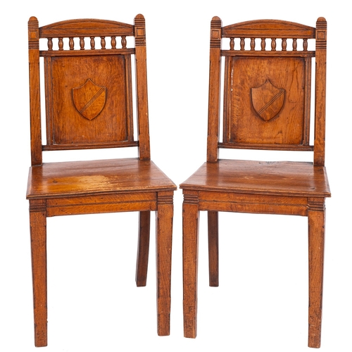 982 - A pair of Victorian oak hall chairs, late 19th century; the backrests with shallow arched tops above... 