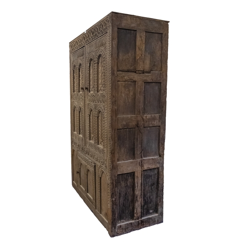 783 - A Jacobean carved oak linen cupboard, basically 17th century with adaptions; the relief carved friez... 