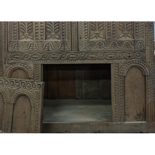 783 - A Jacobean carved oak linen cupboard, basically 17th century with adaptions; the relief carved friez... 