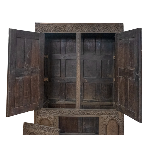 783 - A Jacobean carved oak linen cupboard, basically 17th century with adaptions; the relief carved friez... 