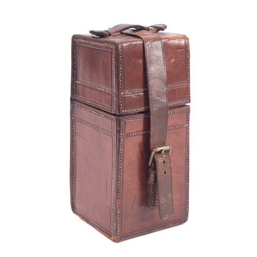 33 - An early 20th century leather cased travelling decanter, the glass decanter in a rectangular case st... 