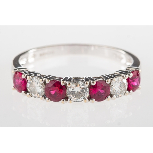 1109 - An 18ct gold ruby & diamond half eternity ring, claw set with alternating circular-cut rubies and br... 