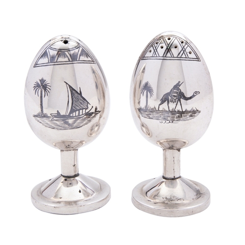 324 - A pair of mid 20th century Iraqi silver salt and pepper, not marked, of egg shape, raised on pedesta... 