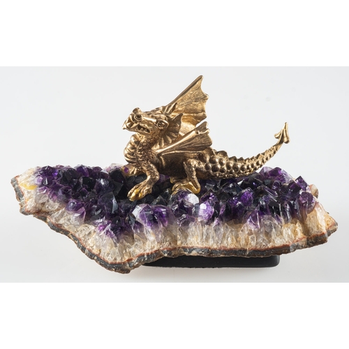 414 - A 9ct gold model of a dragon sat atop a slice of amethyst geode, designed by Phil Read for the Expre... 