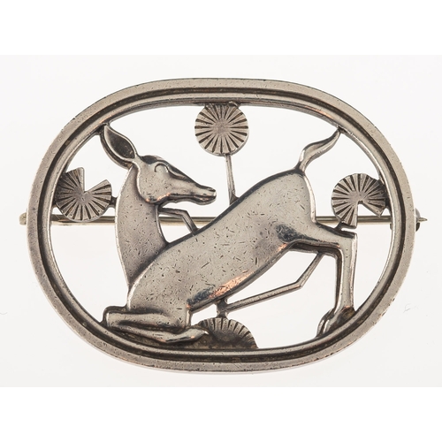 415 - Arno Malinowski, for Georg Jensen.  A silver oval openwork brooch, depicting a kneeling deer with fo... 