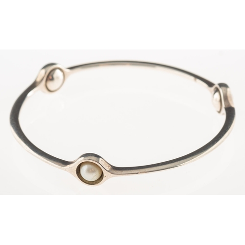 416 - Georg Jensen.  A sphere bangle, interspaced with three pearls, marked 925s, signed Georg Jensen, 473... 