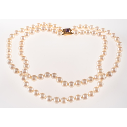 622 - A cultured pearl necklace with an amethyst set clasp, a double row of white cultured pearls with cre... 