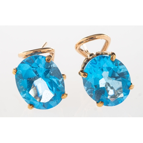 635 - A pair of blue topaz earrings, each claw set with an oval mixed-cut blue topaz, post & safety clip f... 