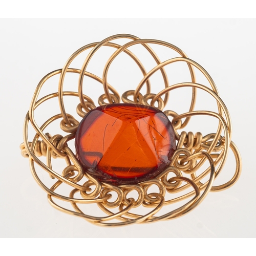 683 - An openwork brooch pendant, set to the centre with a faceted orange paste stone, fitted with a brooc... 