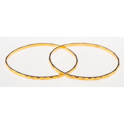 787 - Two 18ct gold bangles, each with engraved design, one with UK hallmark and one with UK import mark, ... 