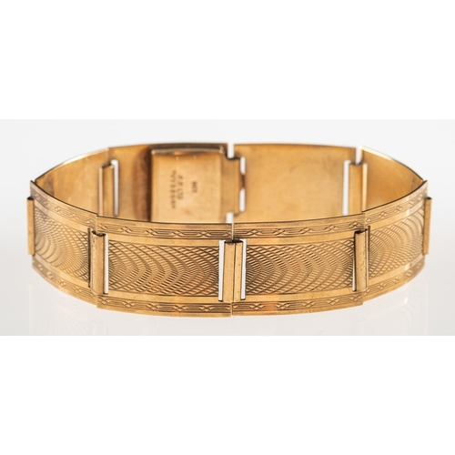 801 - An Art Deco bracelet, made up of articulated rectangular links with engine turned engraving, push-in... 