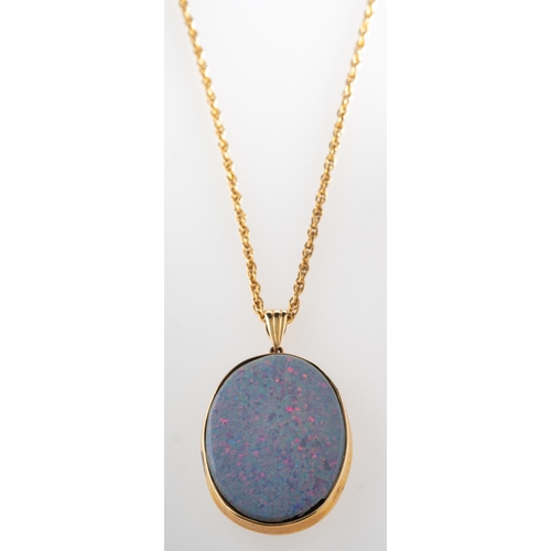 815 - An opal pendant with chain, an oval pendant set with oval-cut slices of opal to the front and back o... 