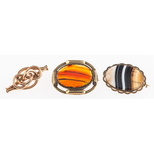 831 - A group of three brooches, including two gilt framed agate set brooches, both unmarked; and an openw... 