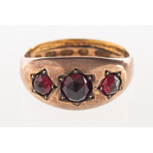 900 - An antique garnet ring, set with three faceted garnets in an enclosed back setting, the ring has two... 