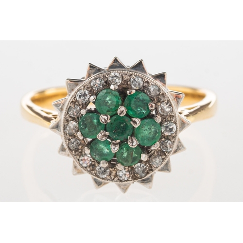 936 - An emerald and diamond cluster ring, of flowerhead form, set with circular-cut emeralds with a halo ... 