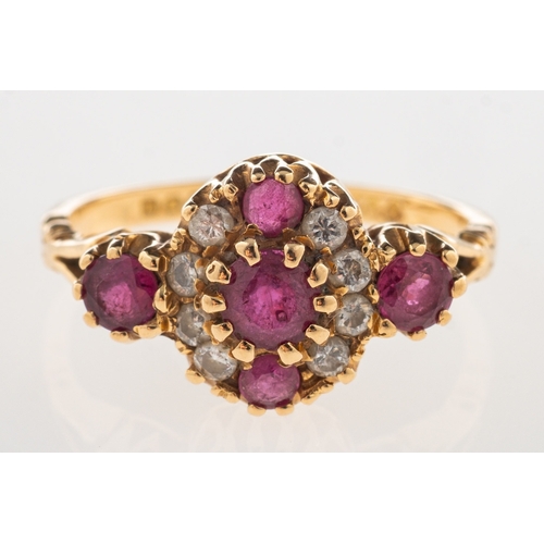 951 - An 18ct gold ruby and diamond cluster ring, set to the centre with a line of three circular-cut rubi... 