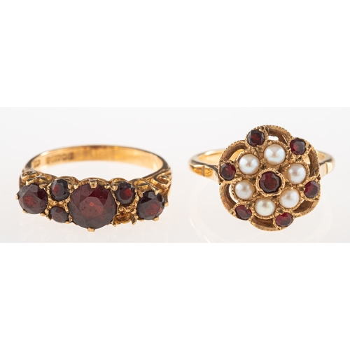 952 - Two 9ct gold garnet set rings, including an openwork flowerhead designed ring set with circular-cut ... 