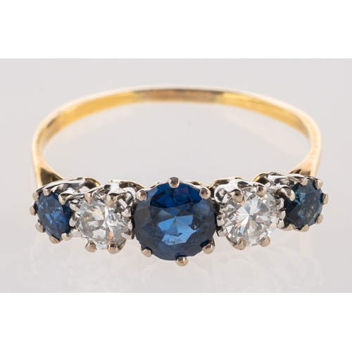 956 - A five stone sapphire and diamond ring, claw set with three circular-cut sapphires and two brilliant... 