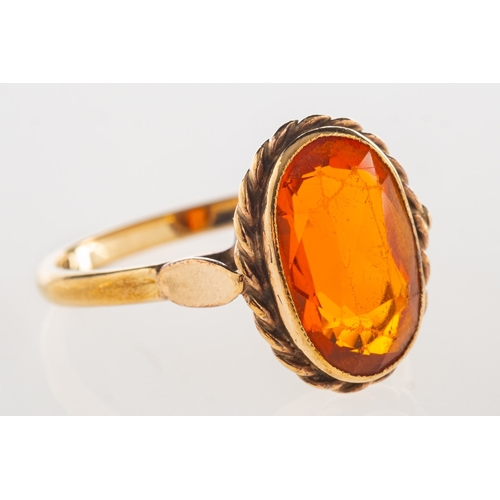 972 - A 9ct gold ring, bezel and rope twist set with an oval-cut orange stone, UK hallmark, size Q1/2, 3.4... 