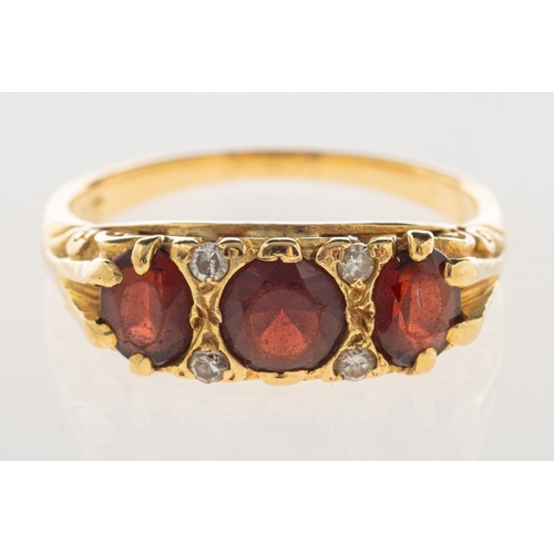 973 - An antique garnet and diamond ring, set with a circular-cut garnet and two oval-cut garnets and thre... 