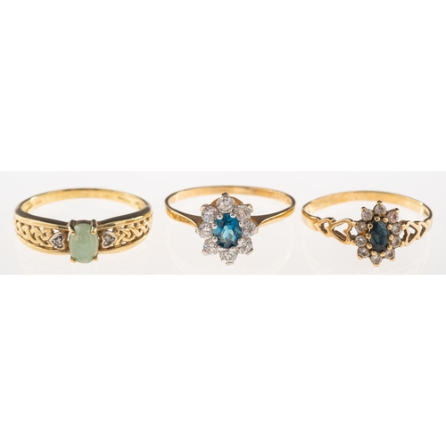 977 - A group of three 9ct gold rings, including a cluster ring set with a central oval-cut blue stone wit... 