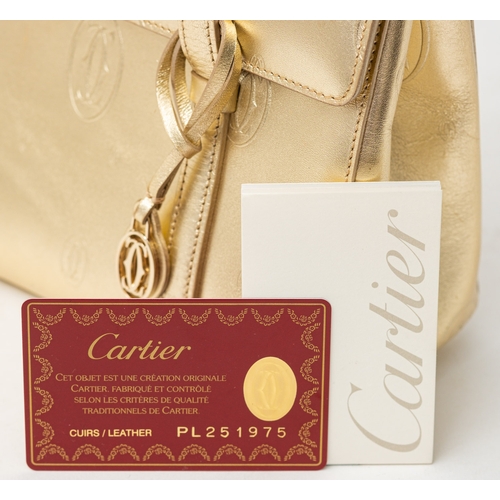 541 - Cartier. A gold monogrammed exterior, beige suede interior, gold hardware and gold safety bar inset ... 