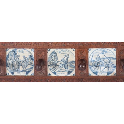 1006 - A 19th Century carved oak wall mounted hat and coat rack, inset with six Delft blue and white potter... 