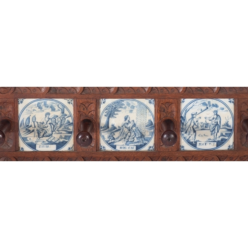 1006 - A 19th Century carved oak wall mounted hat and coat rack, inset with six Delft blue and white potter... 