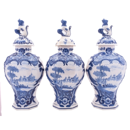 120 - A garniture of five Dutch delftware vases, three of flattened baluster form with domed covers with l... 