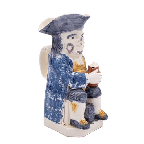 141 - A Staffordshire creamware toby jug holding a foaming jug with a barrel between his legs and pipe to ... 