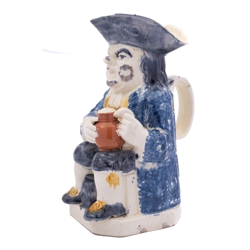 141 - A Staffordshire creamware toby jug holding a foaming jug with a barrel between his legs and pipe to ... 