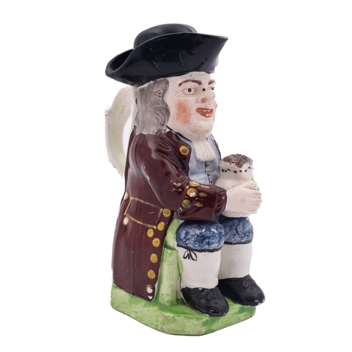 144 - A 19th century Staffordshire toby jug and cover modelled holding a floral decorated foaming jug, wea... 