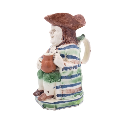 145 - A rare Staffordshire creamware 'striped coat' toby jug modelled holding a brown foaming jug, his coa... 