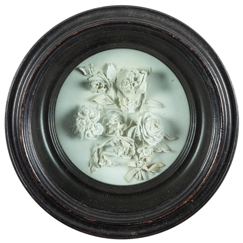 183 - A Champion's Bristol white biscuit porcelain circular plaque applied with a ribbon tied bouquet of f... 