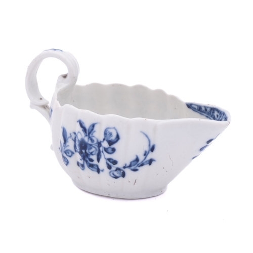 219 - A Champion's Bristol blue and white creamboat of lobed form with scroll handle, painted with flower ... 