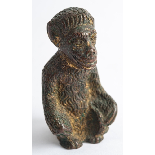 384 - A Continental gilt bronze model of a seated ape, early 20th century; 6cm high, (gilding extensively ... 