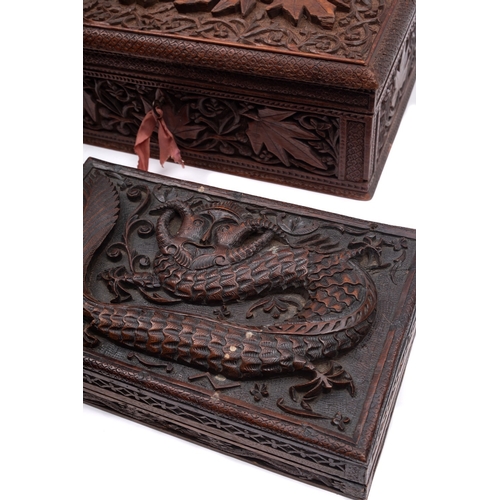 498 - Two South East Asian carved boxes, of rectangular form with hinged lids one carved with mythical bea... 