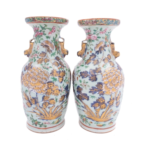 81 - A pair of Chinese Canton famille rose baluster vases with lion-dog handles, painted with peony, lotu... 