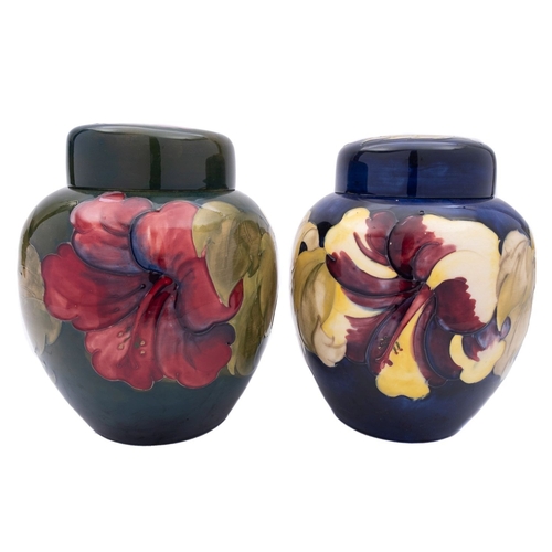 22 - Two Walter Moorcroft pottery jars and covers tube lined in the Hibiscus pattern reserved on a blue a... 